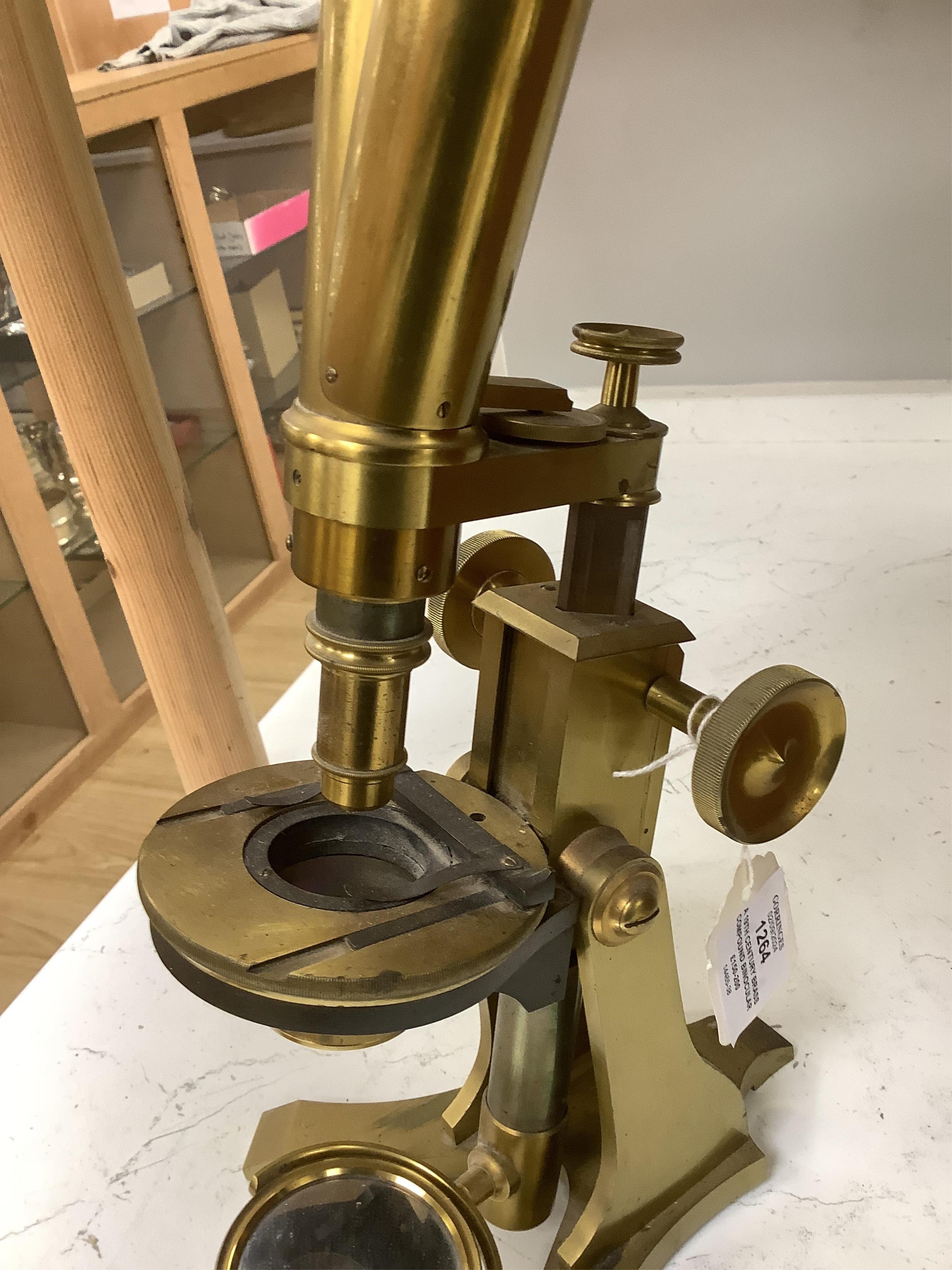 A 19th century brass compound binocular microscope, engraved to the base Baker, 244 High Holborn, London, with four brass cased objective lenses, 47cm high. Condition - fair to good